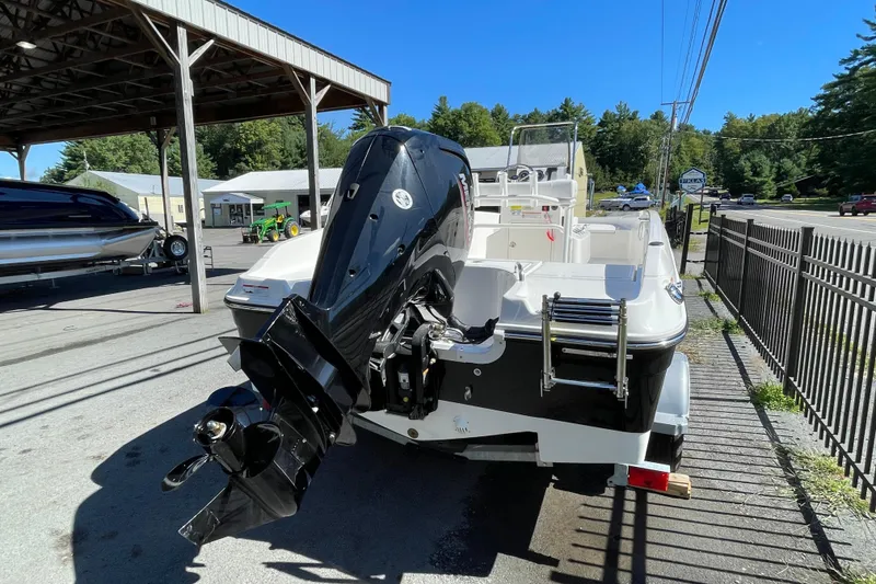 Slide: The Image of 2025 Bayliner Trophy T18 boat with powerful outboard motor, parked outdoors. - 7