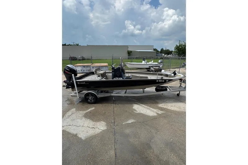 Slide: The Image of 2020 Excel 203 Bay Pro boat on trailer, parked outdoors under cloudy sky. - 2