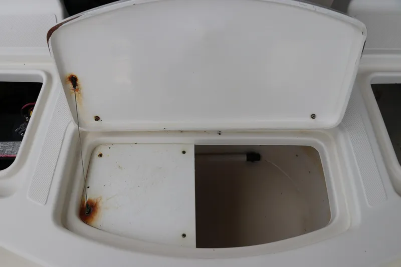 Slide: The Image of Open storage compartment on 2004 Pioneer 175 Bay Sport boat, showing rust and wear. - 12