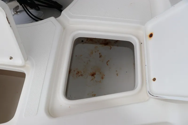 Slide: The Image of Open storage compartment on a 2004 Pioneer 175 Bay Sport boat, showing rust and wear. - 13