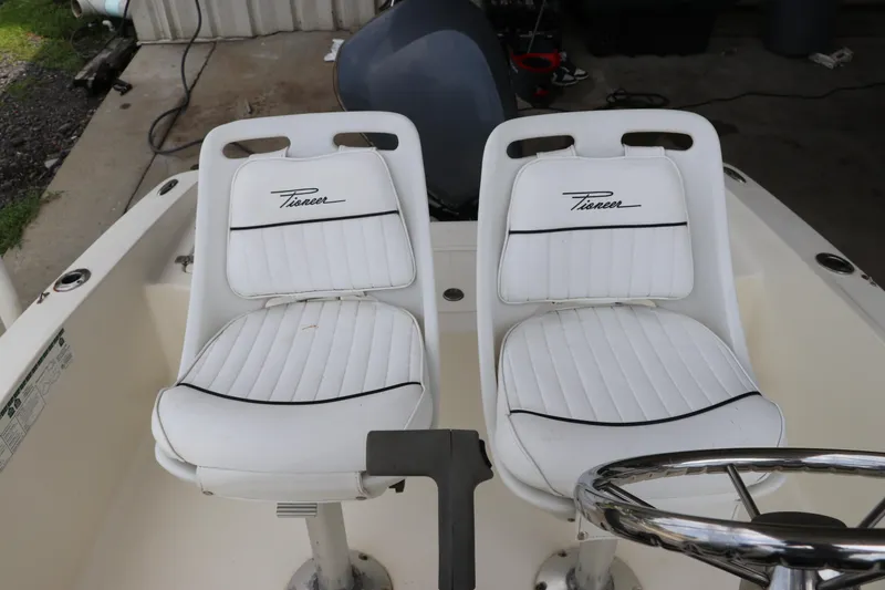 Slide: The Image of 2004 Pioneer 175 Bay Sport boat with white cushioned seats and steering wheel. - 14