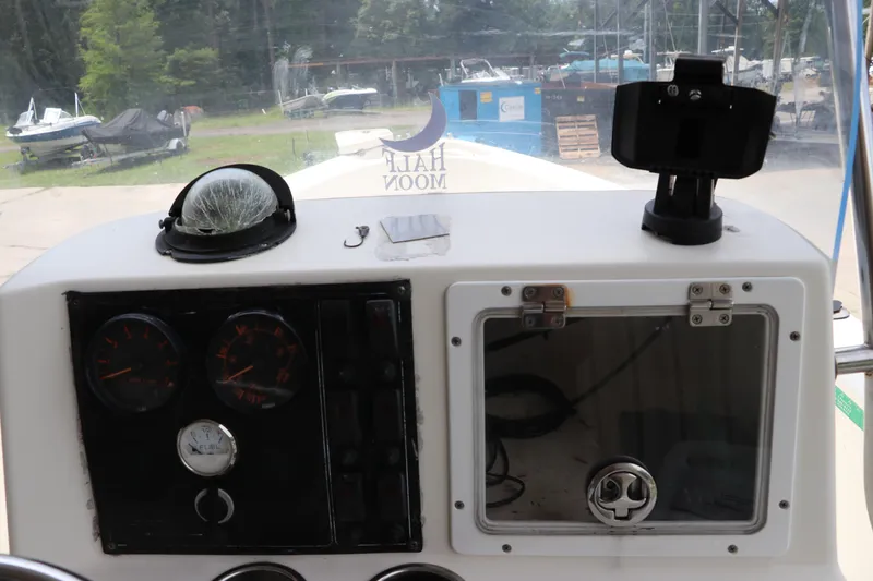 Slide: The Image of Dashboard of a 2004 Pioneer 175 Bay Sport boat with gauges and storage compartment. - 15