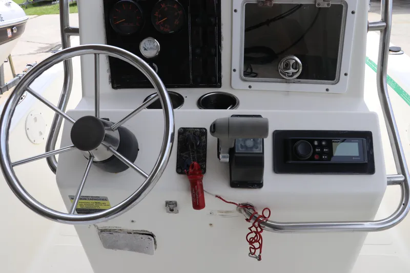 Slide: The Image of 2004 Pioneer 175 Bay Sport boat dashboard with steering wheel and control panel. - 16