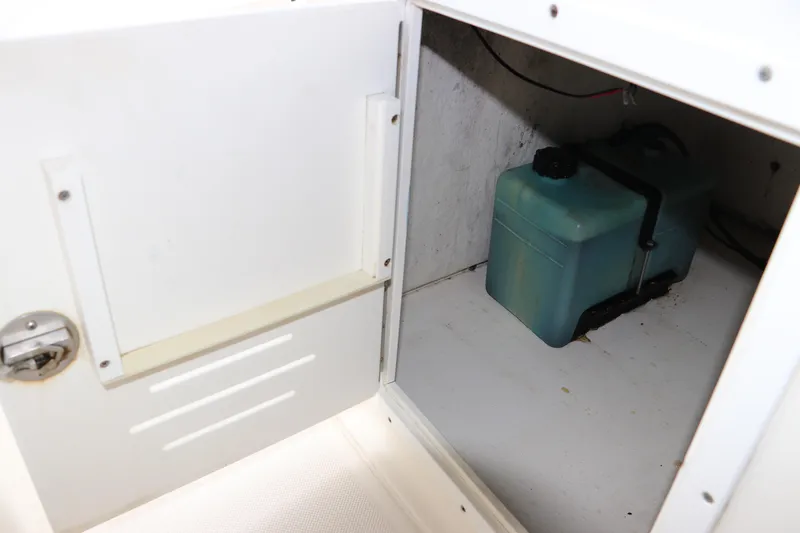 Slide: The Image of Storage compartment with a blue tank inside a 2004 Pioneer 175 Bay Sport boat. - 27