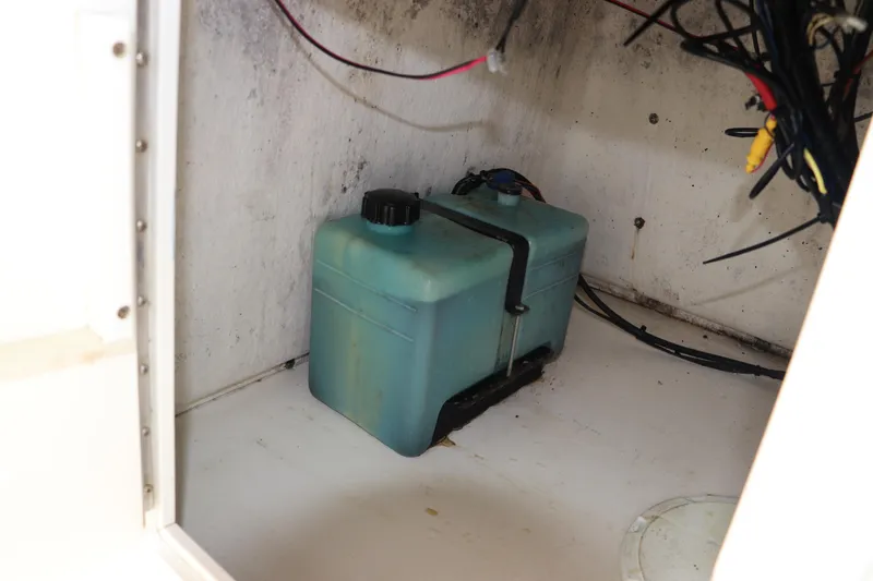 Slide: The Image of Storage compartment of a 2004 Pioneer 175 Bay Sport boat with a blue container. - 28