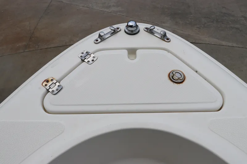 Slide: The Image of Bow storage compartment of 2004 Pioneer 175 Bay Sport boat, featuring metal hinges and latch. - 37