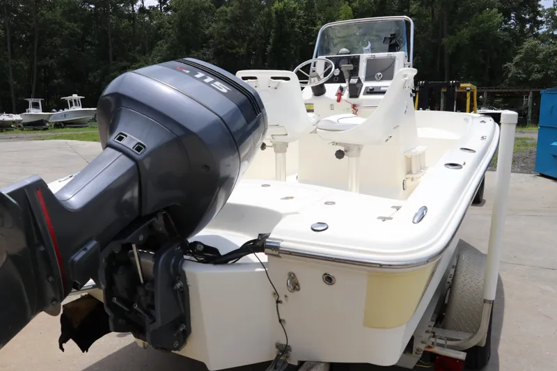 Slide: The Image of 2004 Pioneer 175 Bay Sport boat with outboard motor, parked outdoors. - 5