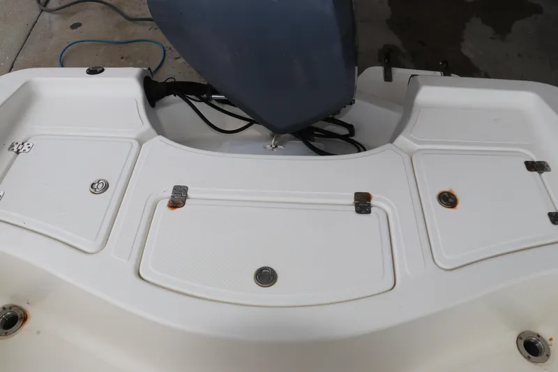 Slide: The Image of 2004 Pioneer 175 Bay Sport boat deck with storage compartments and motor. - 9