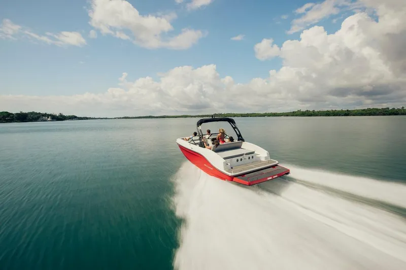 Slide: The Image of 2024 Bayliner DX 2050 speeding on a serene lake under a cloudy sky. - 10