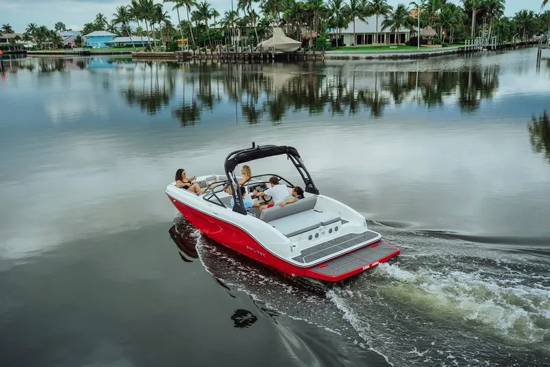 Slide: The Image of 2024 Bayliner DX 2050 boat cruising on a serene lake with passengers enjoying the ride. - 4