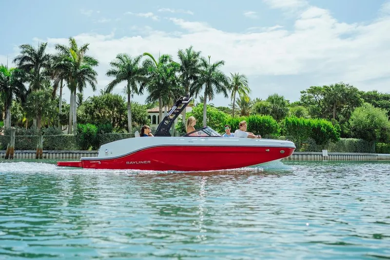 Slide: The Image of 2024 Bayliner DX 2050 boat cruising on a scenic waterway with palm trees. - 5