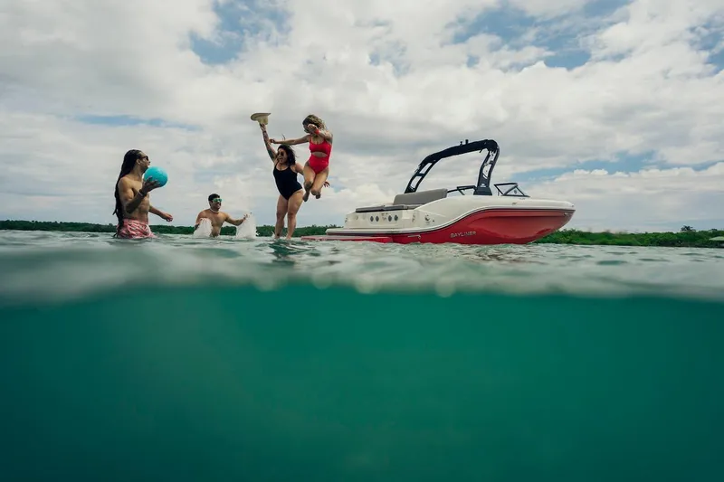 Slide: The Image of People enjoying water activities near a 2024 Bayliner DX 2050 boat. - 6