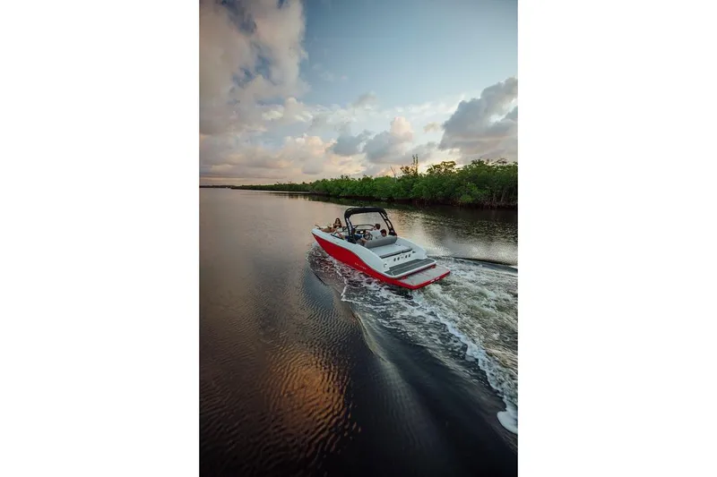 Slide: The Image of 2024 Bayliner DX 2050 cruising on a serene river at sunset. - 7