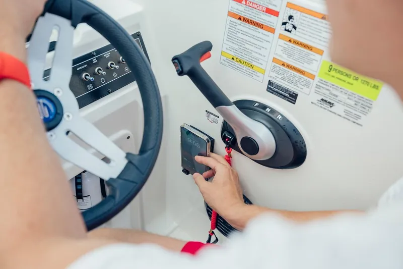 Slide: The Image of 2024 Bayliner DX 2050 boat dashboard with steering wheel and control panel. - 9