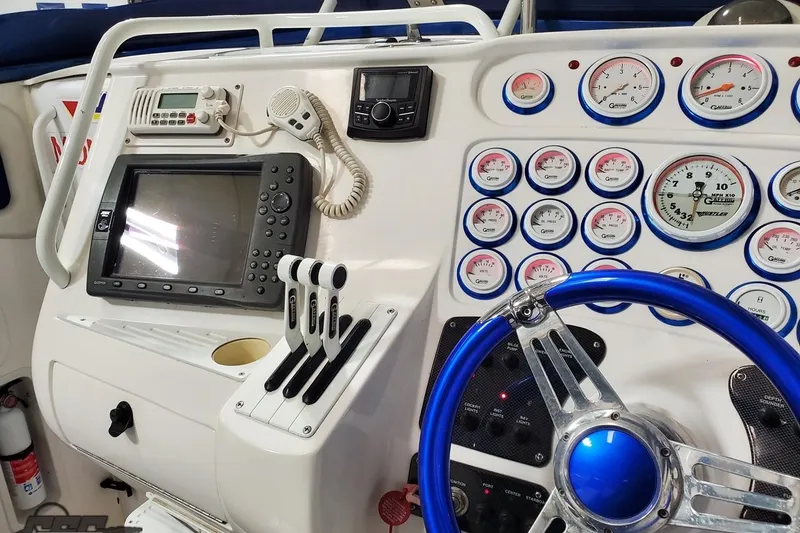 Slide: The Image of Control panel of a 2001 Hustler 50 Monster boat with gauges and steering wheel. - 23