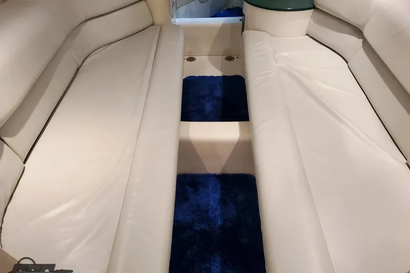 Slide: The Image of Interior of a 2001 Hustler 50 Monster boat with white seating and blue carpet. - 31