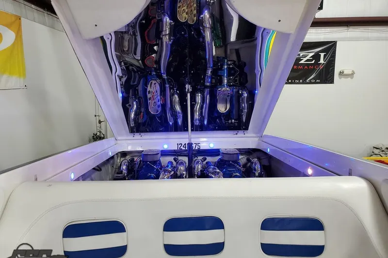 Slide: The Image of 2001 Hustler 50 Monster boat engine compartment with open hatch, showcasing chrome components. - 37