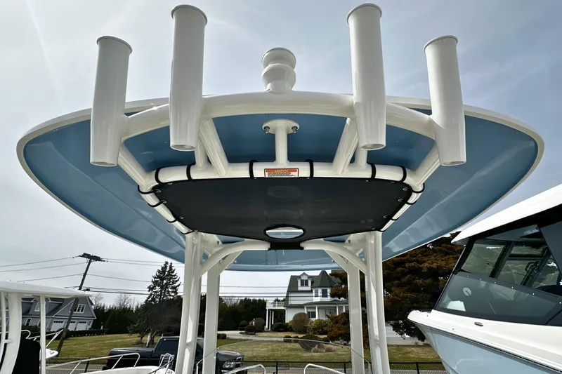 Slide: The Image of 2026 Boston Whaler 220 Dauntless boat with rod holders and blue T-top. - 12