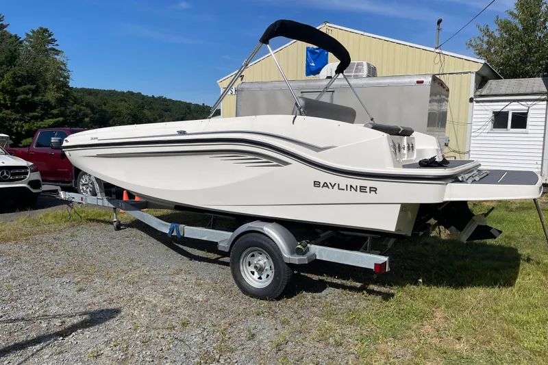 Slide: The Image of 2024 Bayliner DX 2050 boat on trailer, parked outdoors near buildings. - 1