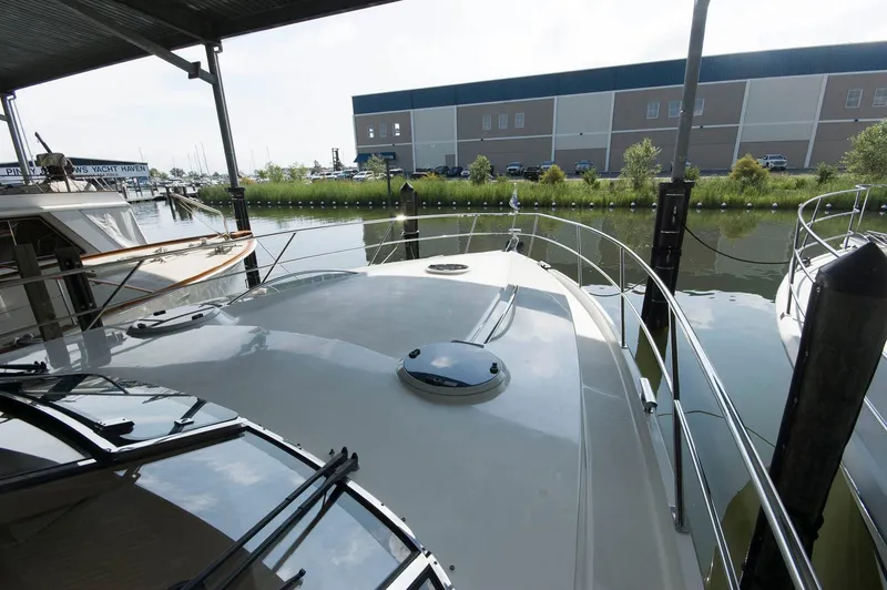 Slide: The Image of 2001 Neptunus 56 Express yacht docked in a marina, under a covered area. - 12