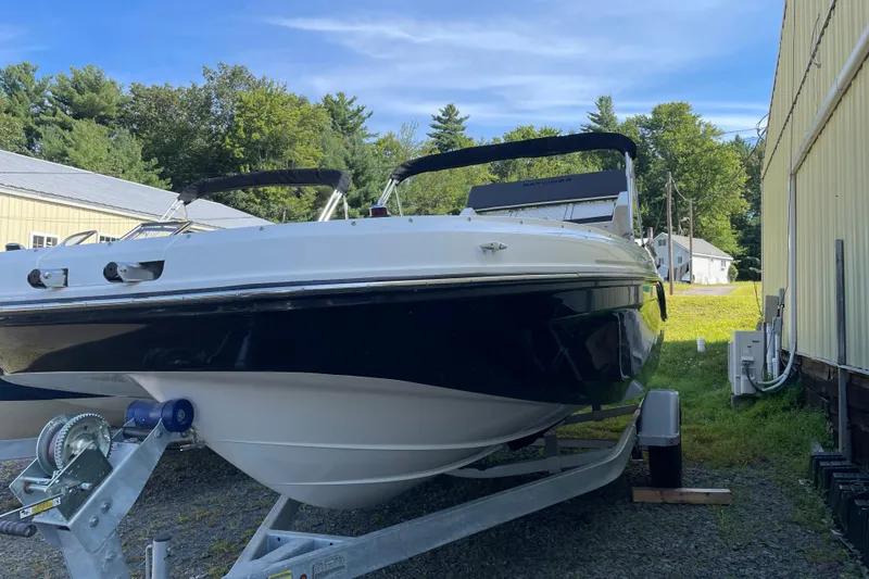 The Image of 2024 Bayliner DX 2000 boat on trailer, parked outdoors near buildings. - 0