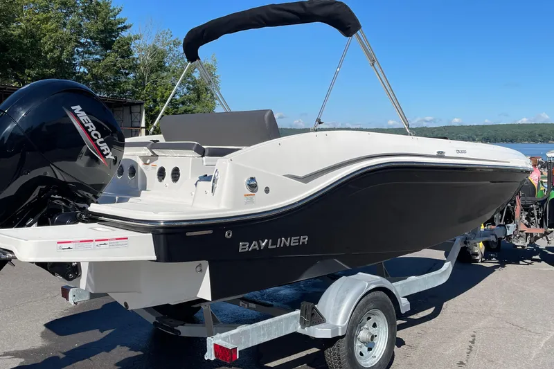 Slide: The Image of 2024 Bayliner DX 2000 boat on trailer, featuring a Mercury outboard motor. - 2