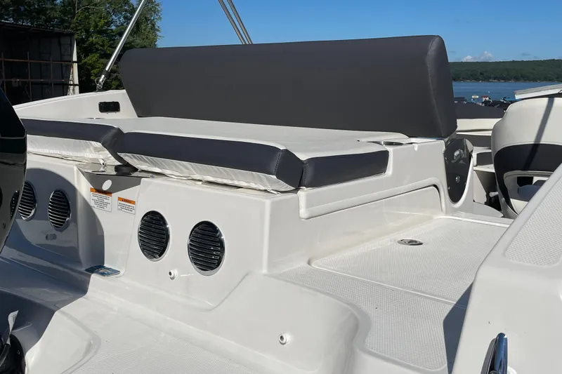 Slide: The Image of 2024 Bayliner DX 2000 boat interior with cushioned seating and speaker system. - 6