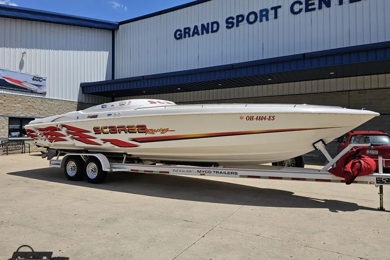 Slide: The Image of 2001 Wellcraft 33 Scarab AVS boat on trailer outside Grand Sport Center. - 13
