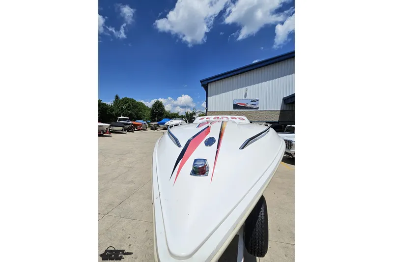 Slide: The Image of 2001 Wellcraft 33 Scarab AVS boat with sleek design, parked outdoors under blue sky. - 16