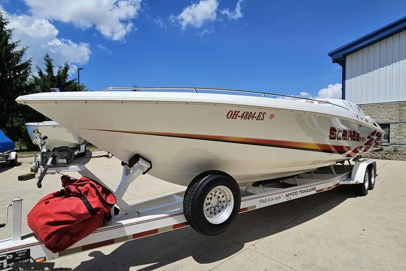Slide: The Image of 2001 Wellcraft 33 Scarab AVS boat on trailer, parked outdoors under blue sky. - 17