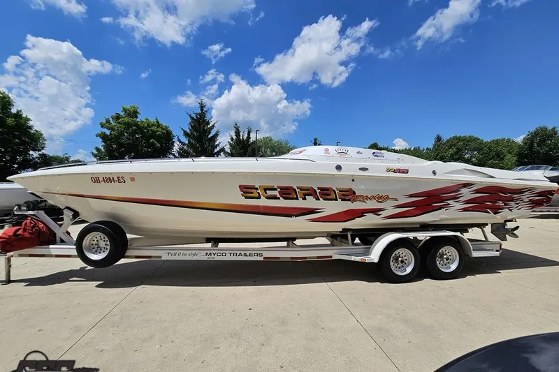 Slide: The Image of 2001 Wellcraft 33 Scarab AVS boat on trailer under blue sky. - 20