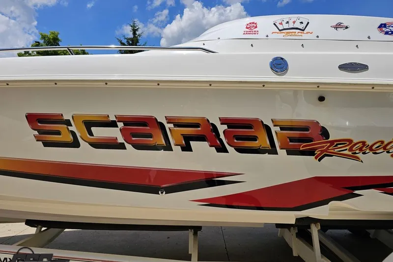 Slide: The Image of 2001 Wellcraft 33 Scarab AVS boat with bold racing graphics and clear sky background. - 23