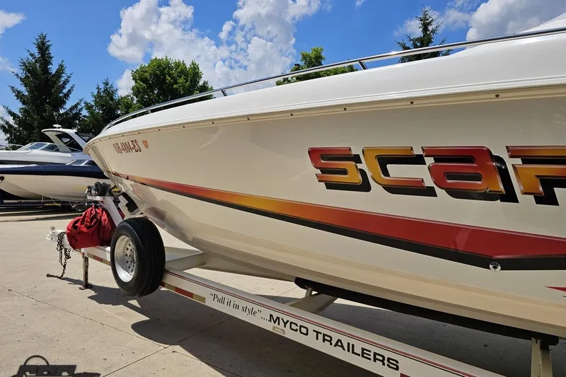 Slide: The Image of 2001 Wellcraft 33 Scarab AVS boat on trailer, vibrant graphics, sunny day. - 24