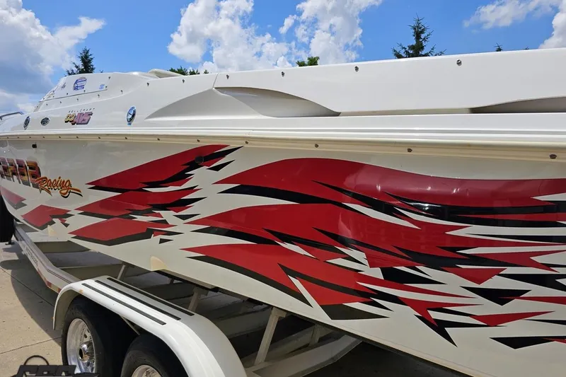 Slide: The Image of 2001 Wellcraft 33 Scarab AVS boat with vibrant red and black racing graphics. - 28