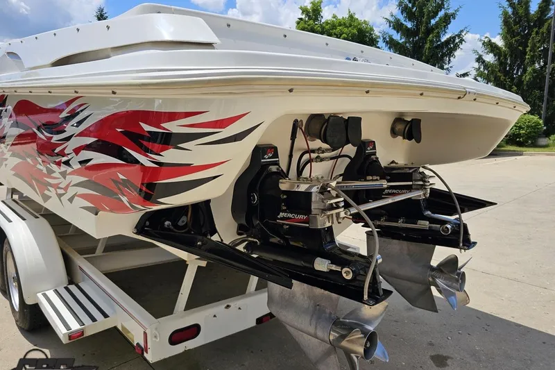 Slide: The Image of 2001 Wellcraft 33 Scarab AVS boat with vibrant red graphics and dual Mercury engines. - 30