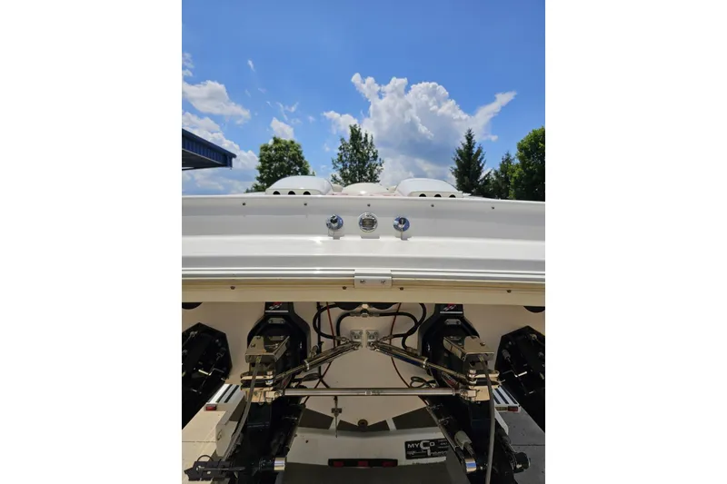 Slide: The Image of Rear view of 2001 Wellcraft 33 Scarab AVS boat under a clear blue sky. - 33