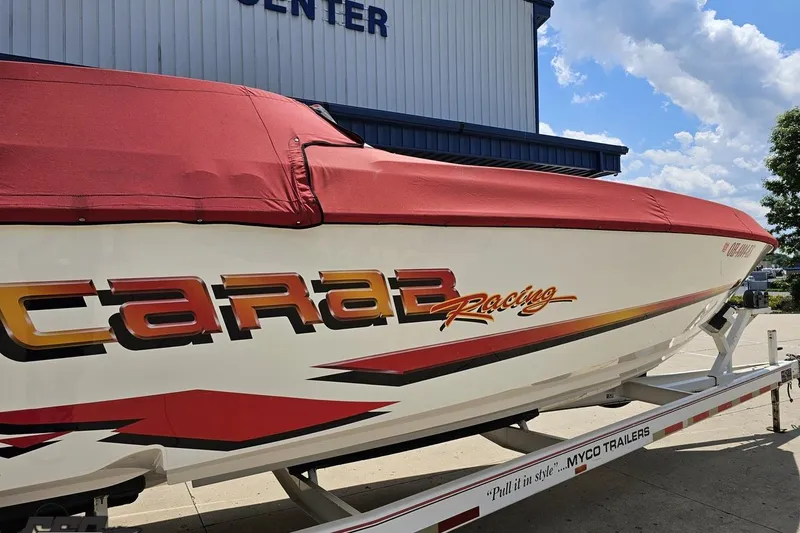 Slide: The Image of 2001 Wellcraft 33 Scarab AVS boat with red cover on trailer, outdoors. - 38