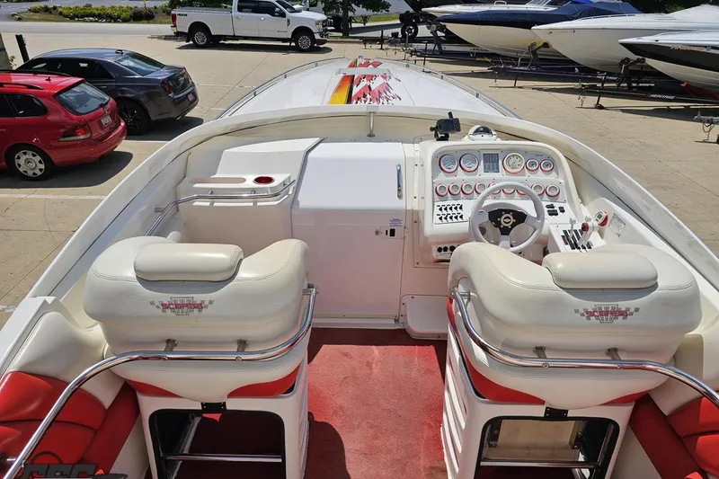 Slide: The Image of 2001 Wellcraft 33 Scarab AVS boat interior with white and red seating, dashboard, and steering wheel. - 48