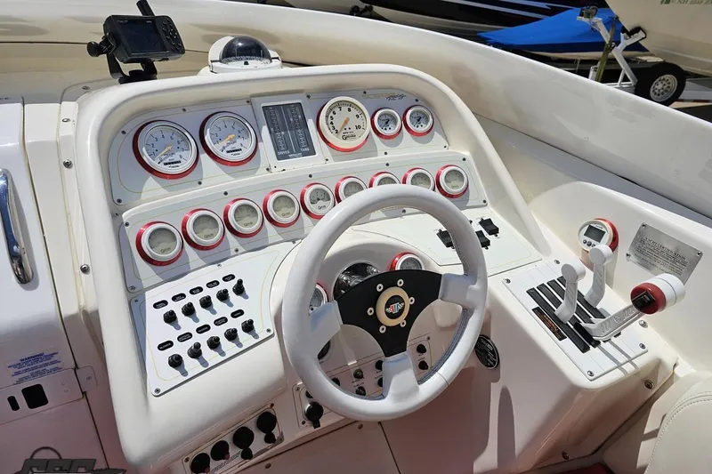 Slide: The Image of 2001 Wellcraft 33 Scarab AVS dashboard with steering wheel and control gauges. - 60