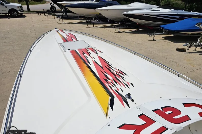 Slide: The Image of 2001 Wellcraft 33 Scarab AVS boat with vibrant graphics, parked on a trailer. - 66