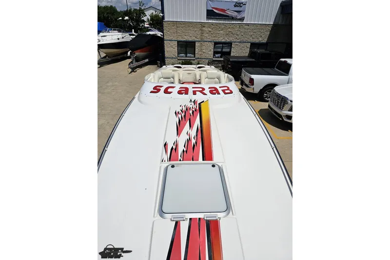 Slide: The Image of 2001 Wellcraft 33 Scarab AVS boat with bold graphics, parked outdoors. - 69