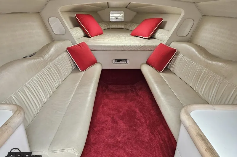 Slide: The Image of 2001 Wellcraft 33 Scarab AVS cabin with beige seating, red carpet, and cushions. - 75