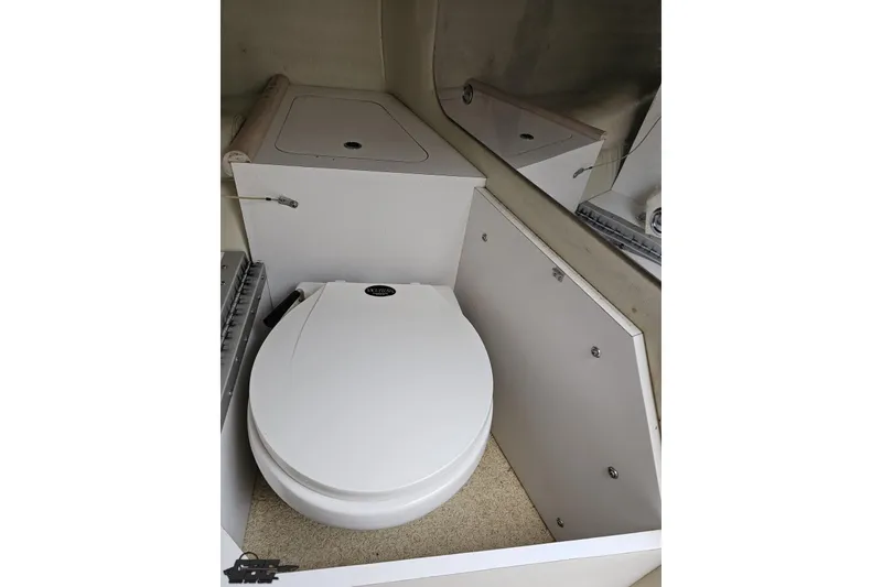 Slide: The Image of 2001 Wellcraft 33 Scarab AVS boat interior with compact white marine toilet. - 80