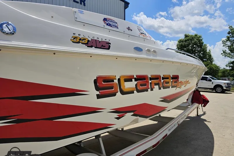 Slide: The Image of 2001 Wellcraft 33 Scarab AVS boat with bold graphics on a trailer. - 9