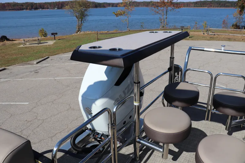 Slide: The Image of Pontoon boat with Vanderbilt 700 Twin engine, lakeside view, and seating area. - 11