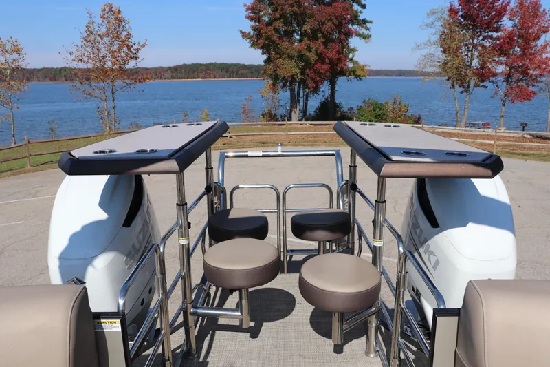 Slide: The Image of 2023 Vanderbilt 700 Twin boat with seating, overlooking a scenic lake view. - 12