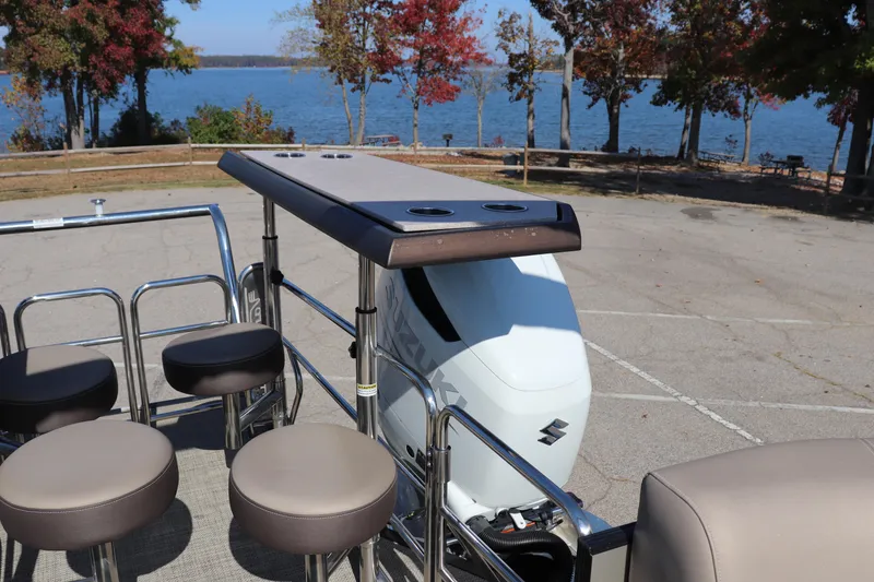 Slide: The Image of 2023 Vanderbilt 700 Twin boat with seating, docked by a scenic lake. - 13