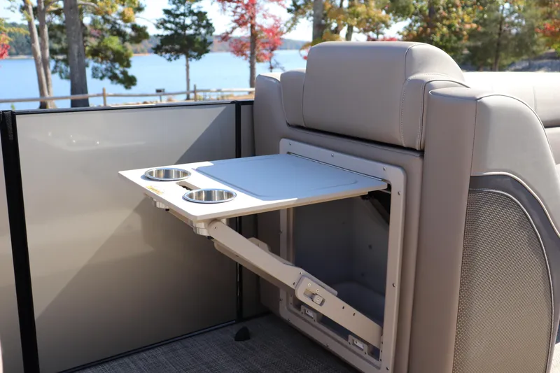 Slide: The Image of 2023 Vanderbilt 700 Twin boat interior with foldable table and cup holders by a lake. - 5