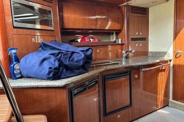 Slide: The Image of Interior of 2005 Sea Ray 390 Sundancer yacht with wooden cabinetry and modern appliances. - 11