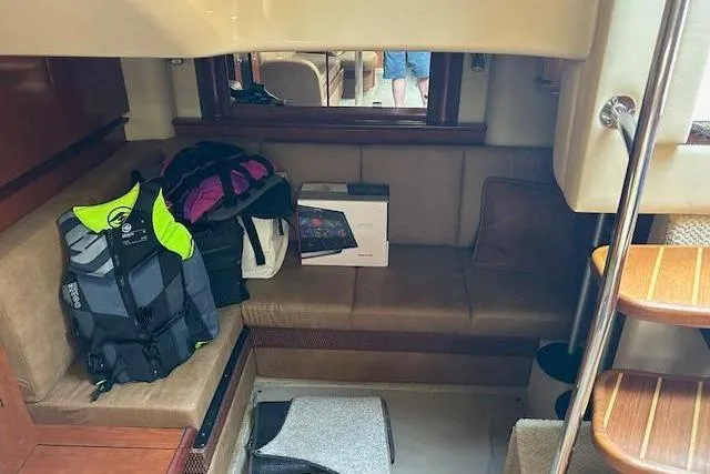 Slide: The Image of Interior of 2005 Sea Ray 390 Sundancer with life jackets and electronics on seating area. - 12